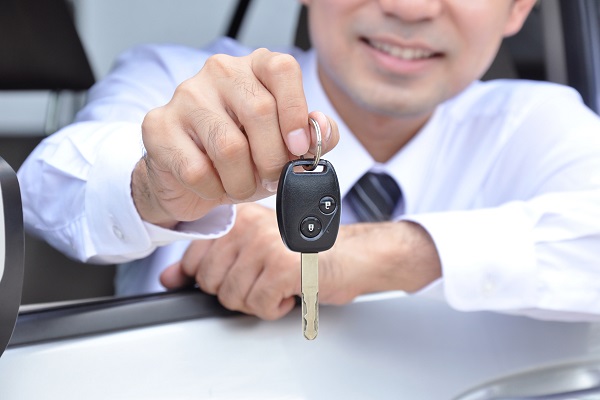 A man showing a car key - car sale & rental service concept